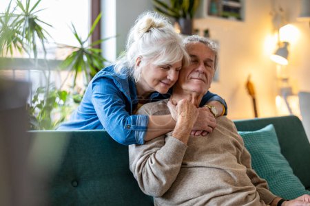 Photo for Portrait of a happy senior couple sitting on sofa at home - Royalty Free Image