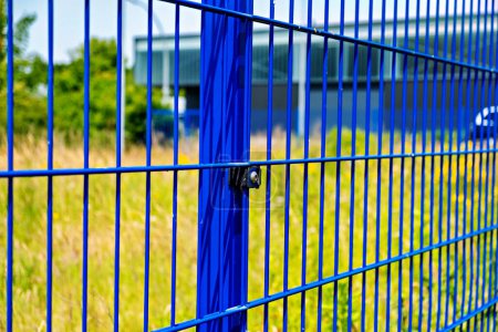 Photo for Close up of blue metal fence with building in the background in Germany. - Royalty Free Image