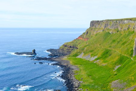 Téléchargez les photos : Les vagues s'écrasent sur la fascinante formation rocheuse hexagonale sur la côte rocheuse d'Irlande du Nord au pont-jetée des Géants. - en image libre de droit
