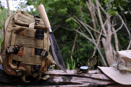 Foto de Mochila de cuchillo con equipo para la supervivencia en el bosque en una madera vieja - Imagen libre de derechos
