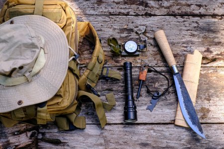 Photo for Knife backpack with equipment for survival in the forest on the old wooden background - Royalty Free Image