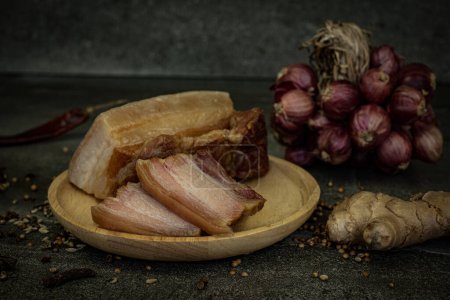 Photo for Yunnan bacon pork on a wooden plate with spices sitting - Royalty Free Image