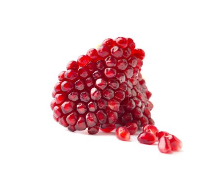 Foto de Beautifully peeled part of a pomegranate and several seeds separately on a white background close-up. Peeled slice of ripe pomegranate with large grains isolated macro shot. - Imagen libre de derechos