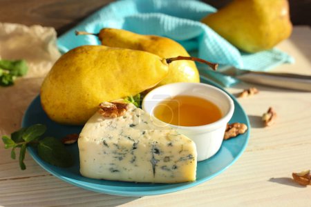 Photo for Blue cheese with pears, nuts and honey on a blue plate. Appetizing Italian composition. Breakfast, lunch. Delicious food concept. Cooking pear and cheese dessert. - Royalty Free Image