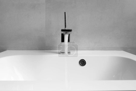 Téléchargez les photos : L'eau se déverse d'un robinet chromé dans un lavabo blanc close-up, le concept d'économie des ressources en eau, la protection des ressources naturelles. - en image libre de droit