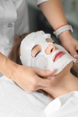 Foto de Face and body treatments. The concept of maintaining health, youth and beauty. Face masks, modern cosmetology, beautician tools, hands with gloves. Beauty techniques. - Imagen libre de derechos