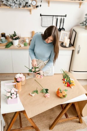 Foto de Girl makes flowers from the soap. Hobby, creative process. DIY gifts. Women's hands and flowers. Handmade soap. Mother's Day, Women's Day. Natural organic products. Flowers on a white table. - Imagen libre de derechos