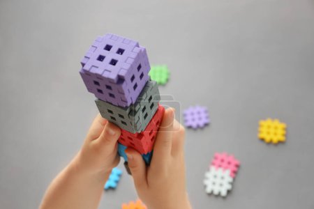 Téléchargez les photos : L'enfant construit à partir d'un constructeur, joue avec des cubes. Jardin d'enfants. Éducation préscolaire, concept de développement de l'enfant, apprentissage des couleurs. Jeux pour la motricité fine de l'enfant. - en image libre de droit
