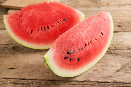 Photo for A slice of ripe watermelon close-up on an old wooden background. Sliced ripe berry. - Royalty Free Image