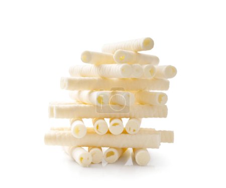 Foto de Crispy vanilla wafer rolls with milk cream are stacked in a beautiful slide on a white background. Heap of crispy waffle sticks with cream filling on isolation. - Imagen libre de derechos