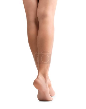 Foto de Slender female legs on a white background rear view. Woman's feet isolated. Foot skin care, depilation, pedicure, hygiene. - Imagen libre de derechos