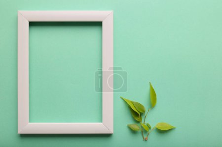 Téléchargez les photos : White frame and sprout on a fresh green background.. Mock up photo frame. Save the planet consept, eco friendly lifestyle. - en image libre de droit