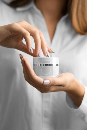 Photo for Beauty woman holding a glass jar of skin cream. Skin care concept. Woman taking care of her dry body. Moisturizing cream in female hands . Beauty treatment. The girl holds a closed jar of cream in her hands - Royalty Free Image