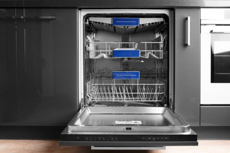 Foto de Modern built-in stainless steel dishwasher with open door in the kitchen front view. Household kitchen appliances. Dishwashing equipment. - Imagen libre de derechos
