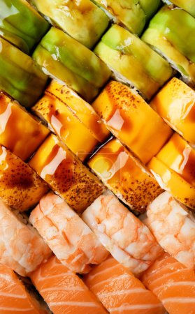 Photo for Set of colorful rolls with shrimp, salmon, avocado, cheese, close-up top view. Asian cuisine, sushi, seafood. - Royalty Free Image
