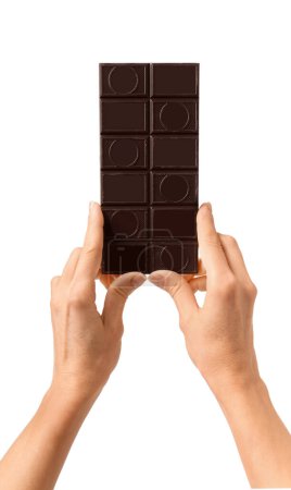 Téléchargez les photos : Une barre de chocolat noir à la main sur fond blanc. Main femelle tenir chocolat sur blanc isolé. - en image libre de droit