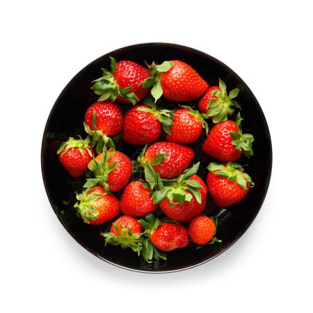 Photo for Large ripe juicy berries of organic strawberries in a black round plate isolated on a white background, top view. - Royalty Free Image