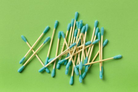 Photo for Bamboo cotton swabs buds sticks on a green background, top view. Eco-friendly items for hygiene, makeup, medicine. - Royalty Free Image