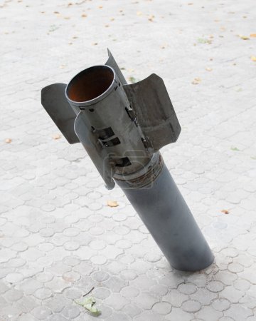 Foto de La cola de una bomba de racimo sobresale del pavimento Múltiples lanzacohetes disparados contra el territorio de Ucrania por invasores rusos, guerra en Ucrania, proyectiles de racimo, armas prohibidas. - Imagen libre de derechos