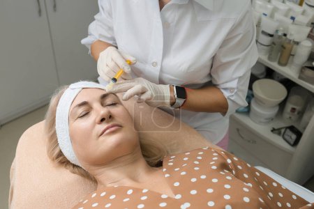 Foto de Face treatments. The concept of maintaining health, youth and beauty. Modern cosmetology, beautician tools. Beauty techniques. Facial mesotherapy. Beauty injections. Botulinum therapy of the face. - Imagen libre de derechos