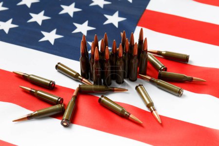 Téléchargez les photos : Des balles pour des armes à feu, des cartouches de l'armée de combat sur le drapeau américain. Le concept de prêt-bail, la fourniture d'armes, le soutien, la vente d'armes. - en image libre de droit