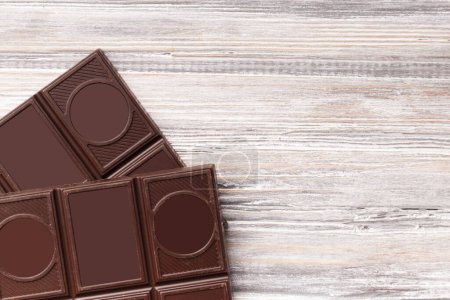 Photo for Dark bitter healthy chocolate on a gray wooden background, top view, with space for text. - Royalty Free Image