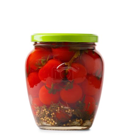 Téléchargez les photos : Tomates cerises en conserve dans un bocal fermé en verre isolé sur fond blanc, gros plan. Tomates marinées aux épices - en image libre de droit