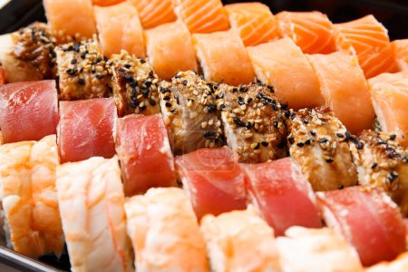 Téléchargez les photos : Un grand ensemble de rouleaux de sushi avec crevettes, saumon, thon, anguille, gros plan. Livraison de sushi. - en image libre de droit