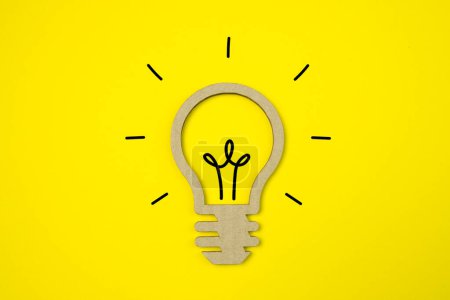 Téléchargez les photos : Flat lay design symbole d'idée avec lampe en carton sur fond jaune pastel. - en image libre de droit