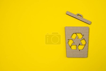 Téléchargez les photos : Symbole du contenant à ordures en papier sur fond jaune. Poubelles, poubelles. Campagne mondiale contre la pollution environnementale, les ordures, les ordures. - en image libre de droit