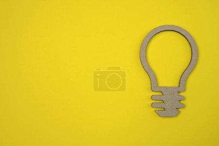 Téléchargez les photos : Ampoule découpée sur un carton ondulé. Design plat symbole de l'idée avec lampe en carton sur fond. - en image libre de droit
