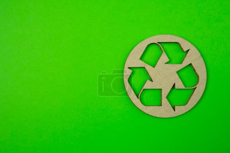 Téléchargez les photos : Découpe de papier de recycler logo sur fond vert avec copyspace gratuit pour vos idées de créativité texte. - en image libre de droit