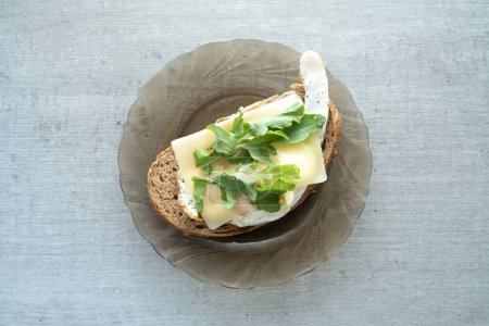 Téléchargez les photos : Œuf frit avec fromage et fines herbes sur le pain pour le petit déjeuner sur assiette et table rustique. - en image libre de droit