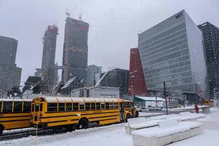 Photo for Montreal, CA - 16 November 2022: Yellow school buses parked in Montreal Downtown during snow storm - Royalty Free Image