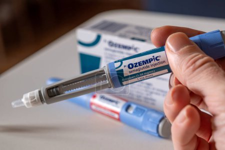 Photo for Montreal, CA - 25 November 2023: Hand holding Ozempic semaglutide injection pen. Ozempic is a medication for obesity - Royalty Free Image