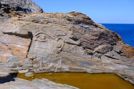 Photo for God Aeolus carved on the rock at Kavalourko Beach near Panormos village - Royalty Free Image