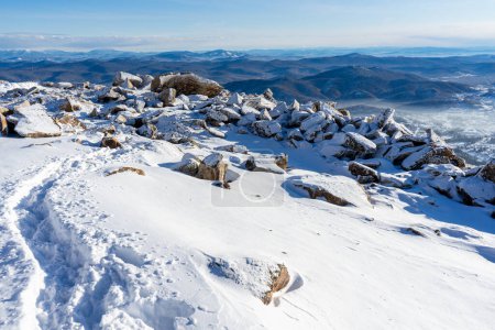 Touristischer Pfad im Schnee. Blick auf die Berge blauer Himmel und das Dorf. Winterlandschaft. Hochwertiges Foto
