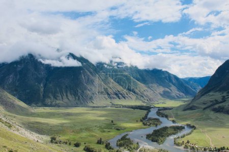 Malerisch grünes Flusstal. Sommerliche Naturlandschaft, wolkenverhangene Berge und blauer Himmel, beste Erholungsgebiete mit herrlicher Aussicht. Republik Altai, Sibirien, Russland.