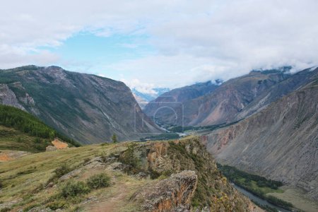Vue du col Katu-Yaryk à la vallée de Chulyshman. De hautes montagnes, une rivière et au-dessous. Saison estivale dans les montagnes Altaï