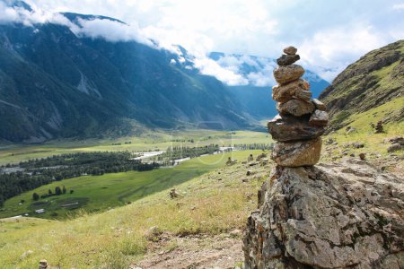Stone pyramid in river valley Chulyshman. Natural mountain landscape Republic Altai, Russia, summer day. tourist place. mountain in clouds. High quality photo