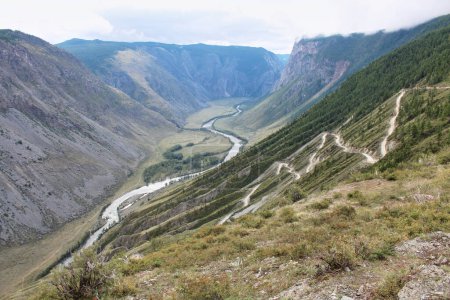 Blick vom Katu-Yaryk Pass auf das Chulyshman Tal. Hohe Berge gefährliche Straße, ein Fluss unten. Altai, Sibirien, Russland. Sommersaison im Altai. 