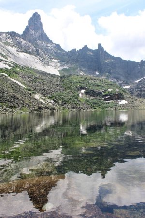Der Gornykh-Dukhov-See ist von hohen, schneebedeckten Berggipfeln umgeben. Wasser, das Berge und Himmel spiegelt. Friedliche und ruhige Atmosphäre, die ein Gefühl der Einsamkeit und Harmonie mit der Natur schafft. Ergaki