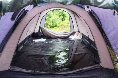 Une flaque d'eau dans une mauvaise tente touristique après un orage. Le choix de l'équipement pour la randonnée et le tourisme. Incident de voyage Tente fuie pendant la pluie. 