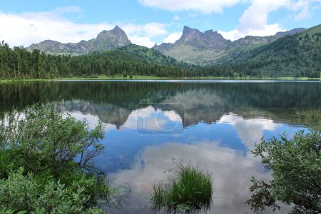 Ufer eines großen Bergsees Svetloye im Naturpark Ergaki. Sommerliche Berglandschaft bei gutem Wetter. ruhiges Wasser und Besinnung, Büsche auf blankem Grund. Sibirien, Russland. Erstaunlicher Reiseblick