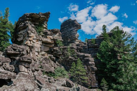 Grupo de asombrosas rocas sienitas en forma de formación de montañas ígneas. capas de magma. Atracción turística y zona de entrenamiento de escalada en la naturaleza salvaje. Caminata en kuturchinskoye belogorye región de Krasnoyarsk