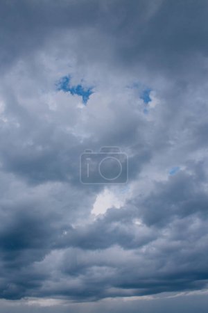 Téléchargez les photos : Nuages sombres et sombres avec des vides bleus de ciel clair. lumière du ciel - en image libre de droit