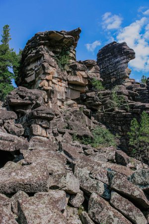 Tourist attraction and Climbing training area in wild nature. Hike at kuturchinskoye belogorye Krasnoyarsk region. Group of Amazing shaped Syenite rocks igneous mountain formation. layers of magma. 