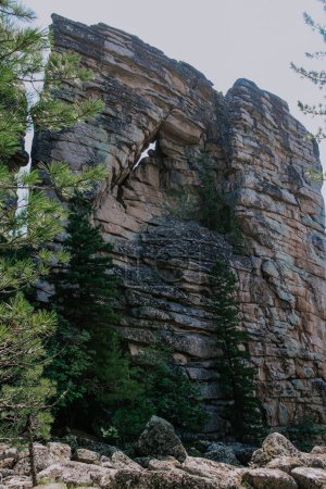 Erstaunlich geformter hoher syeniter Felsen mit durchgehender entzündlicher Gebirgsformation. Schichten von Magma. Touristenattraktion und Klettertrainingsgelände in wilder Natur. Wanderung im Sommer kuturchinskoye belogorye 