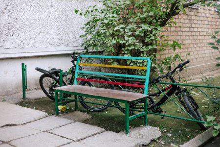 Two bicycles left unattended in the yard near a colorful bench. Security of property in the territory of the CIS countries and the former Soviet Union.