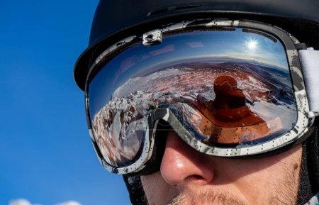 Photo for Reflection in ski goggles close-up: snowy mountain slopes for skiing. Skier's or snowboarder equipment: helmet, mask, glasses on man. Weekend active sport holiday, snowboard resort at winter sunny day - Royalty Free Image